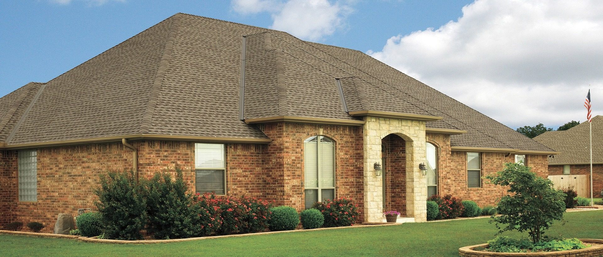 Completed roof on a large brick home with dark architectural shingles